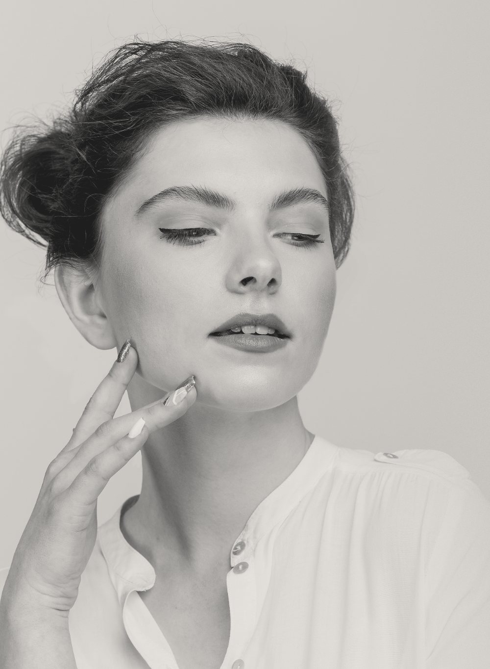 Portrait noir et blanc — une femme, les yeux fermés, la main posée sur la joue